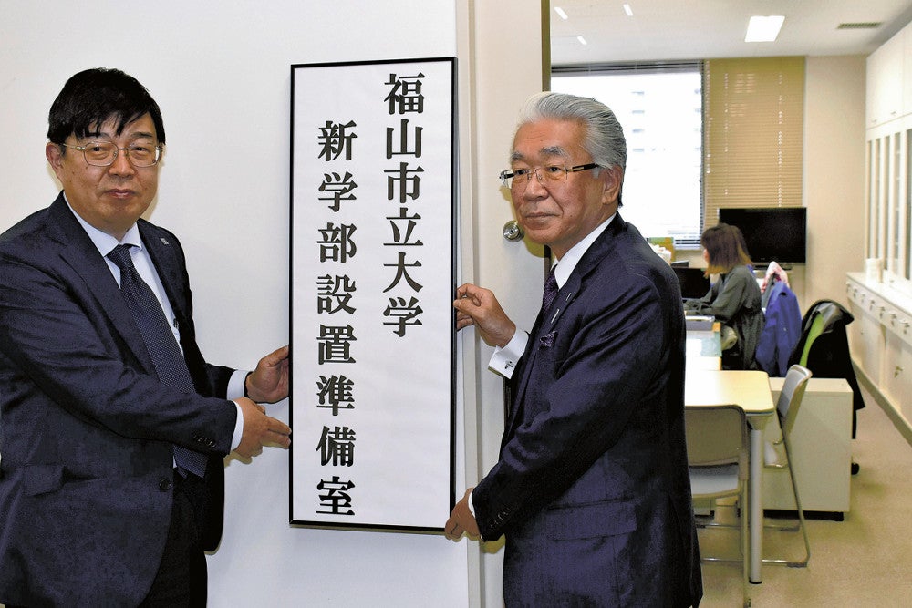 Vorsitzender und Präsident Sato (rechts) halten das Schild für den Vorbereitungsraum hoch (12. April, in der Stadt Fukuyama, Präfektur Hiroshima)