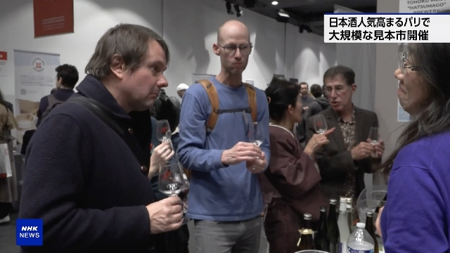 Trinker genießen Sake auf großer Messe in Frankreich